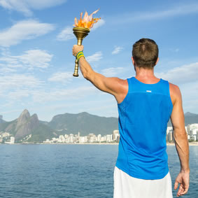 athlète de dos avec la flamme olympique